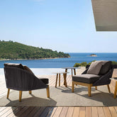 Rattan armless chair with solid wood bottom and gray cushion for outdoor use