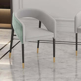 Green velvet upholstered dining chair with modern design and metal accents