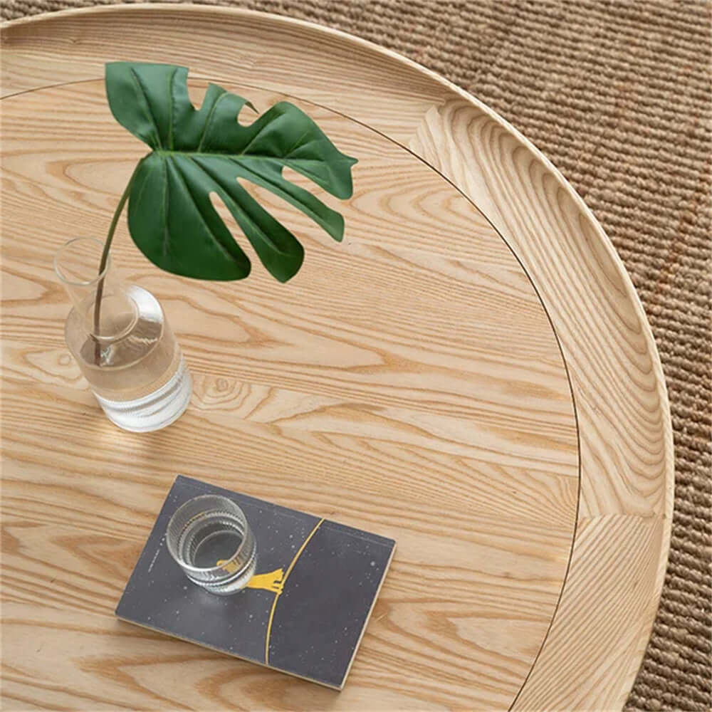 Round Japandi coffee table with solid wood top and rattan base, featuring two tiers for storage