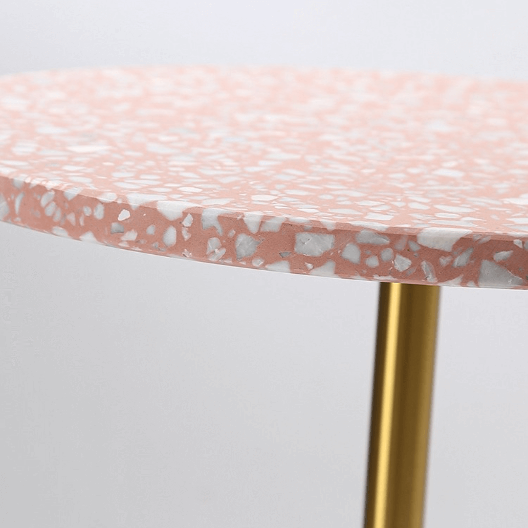 Pink terrazzo coffee table with gold accents in a modern minimalist design