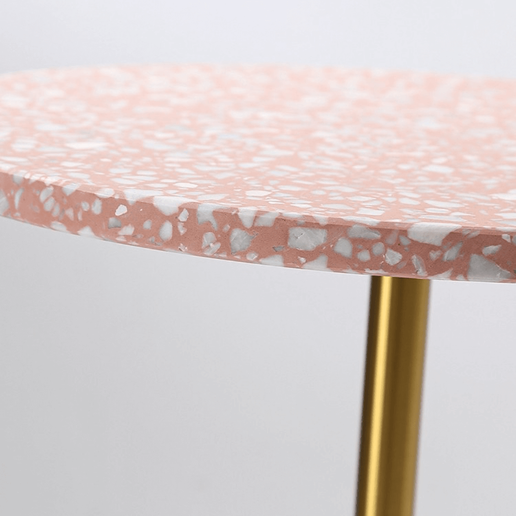 Pink terrazzo coffee table with gold accents in a modern minimalist design