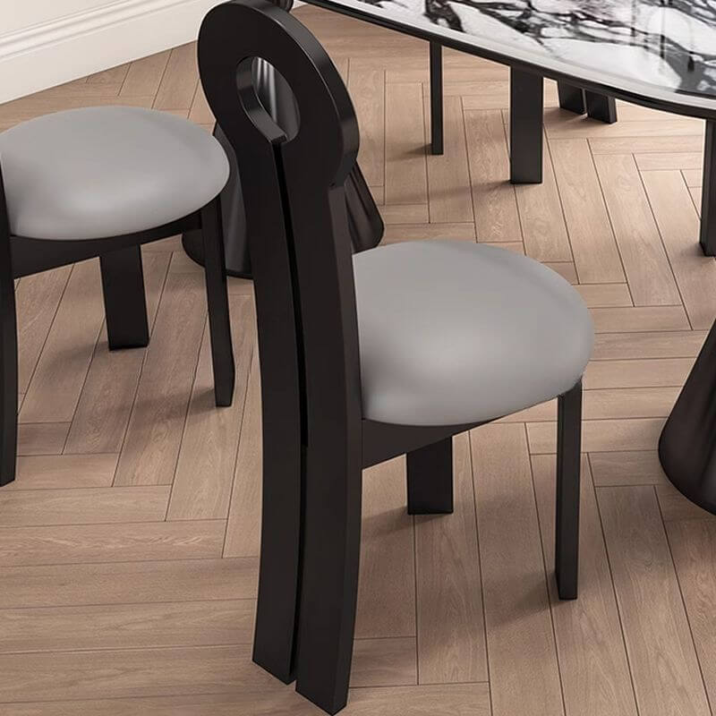 Oval marble dining table set with dual footing, solid back panel, and cushioned chairs