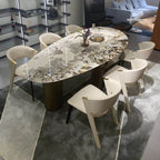 Oval marble dining table with white top and three gold steel legs