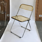 Contemporary acrylic folding armless chair with open back, ideal for dining rooms