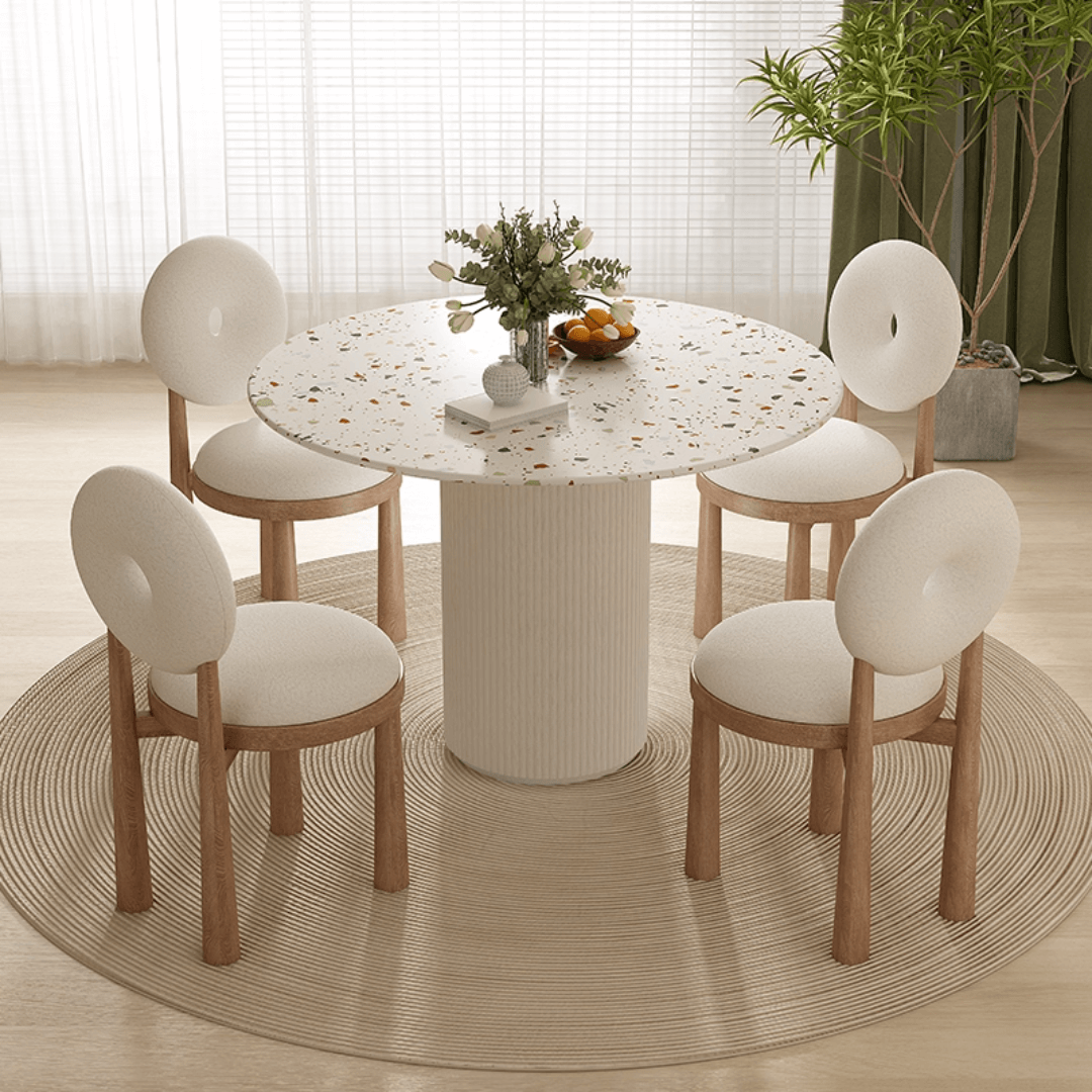 Round terrazzo dining table with soft wool upholstered chairs for a trendy home setup