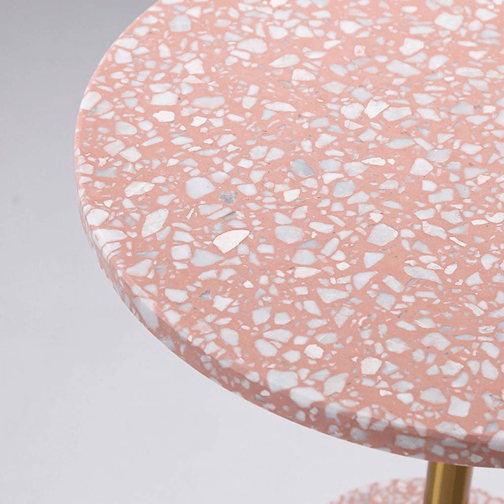 Pink terrazzo coffee table with gold accents in a modern minimalist design