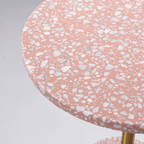 Pink terrazzo coffee table with gold accents in a modern minimalist design