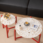 Round side table with vibrant red terrazzo top, featuring a modern minimalist design