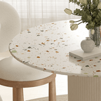 Round terrazzo dining table with soft wool upholstered chairs for a trendy home setup