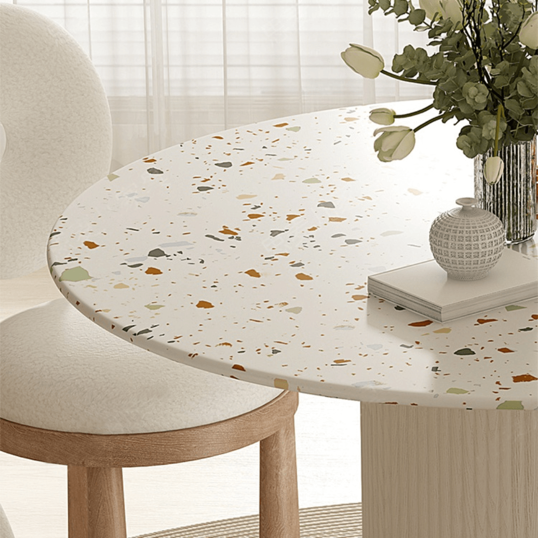 Round terrazzo dining table with soft wool upholstered chairs for a trendy home setup