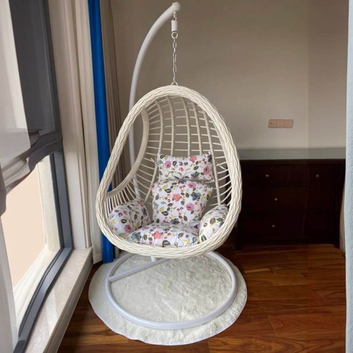 Tropical upholstered porch swing with metal chain and included stand for outdoor relaxation