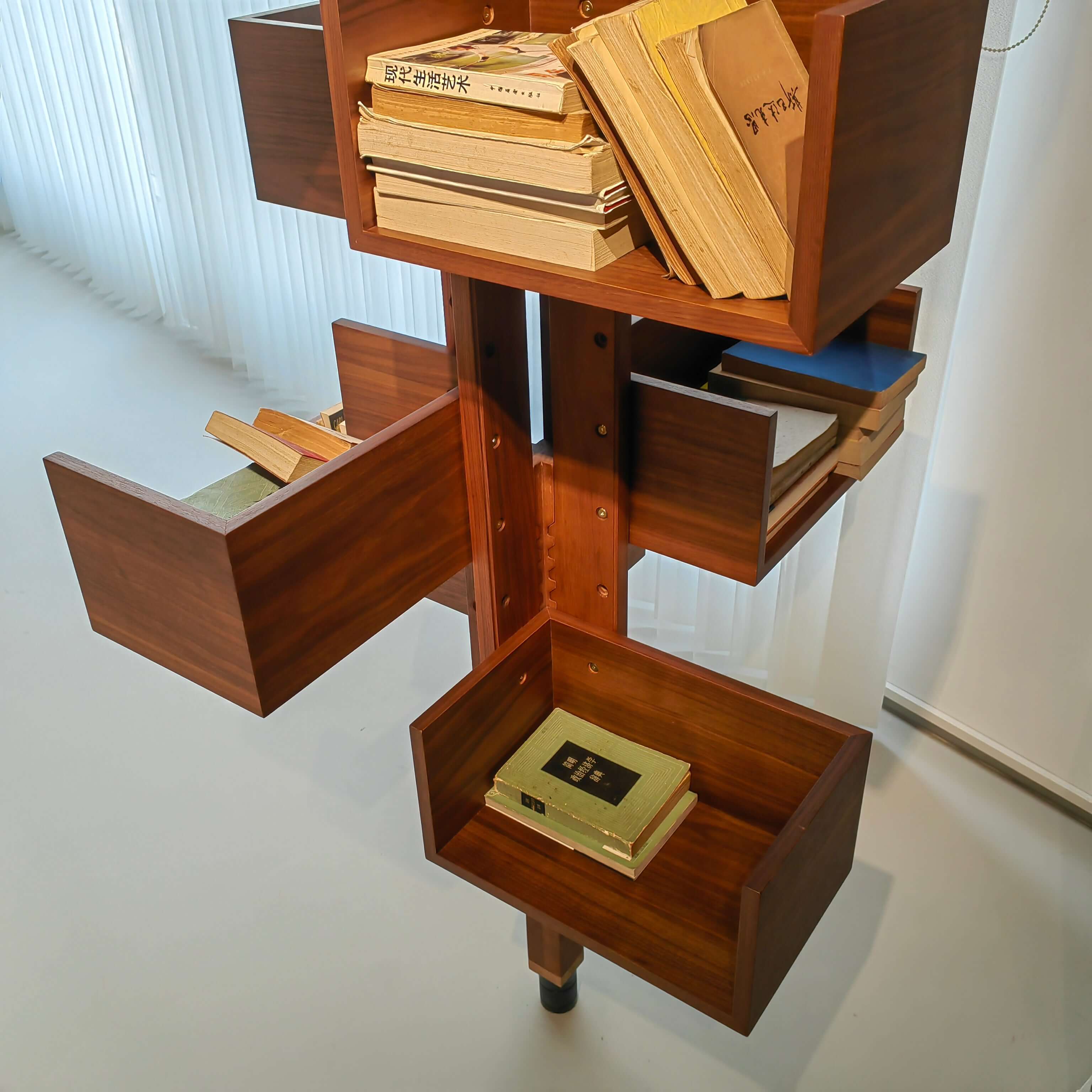 360-degree rotating walnut wood bookshelf extending from floor to ceiling for stylish storage