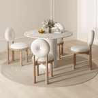Round terrazzo dining table with soft wool upholstered chairs for a trendy home setup