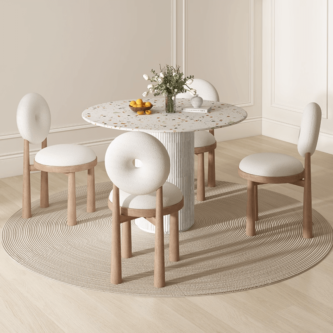 Round terrazzo dining table with soft wool upholstered chairs for a trendy home setup