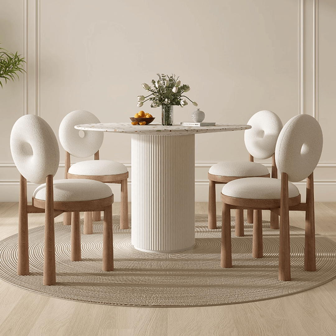 Round terrazzo dining table with soft wool upholstered chairs for a trendy home setup