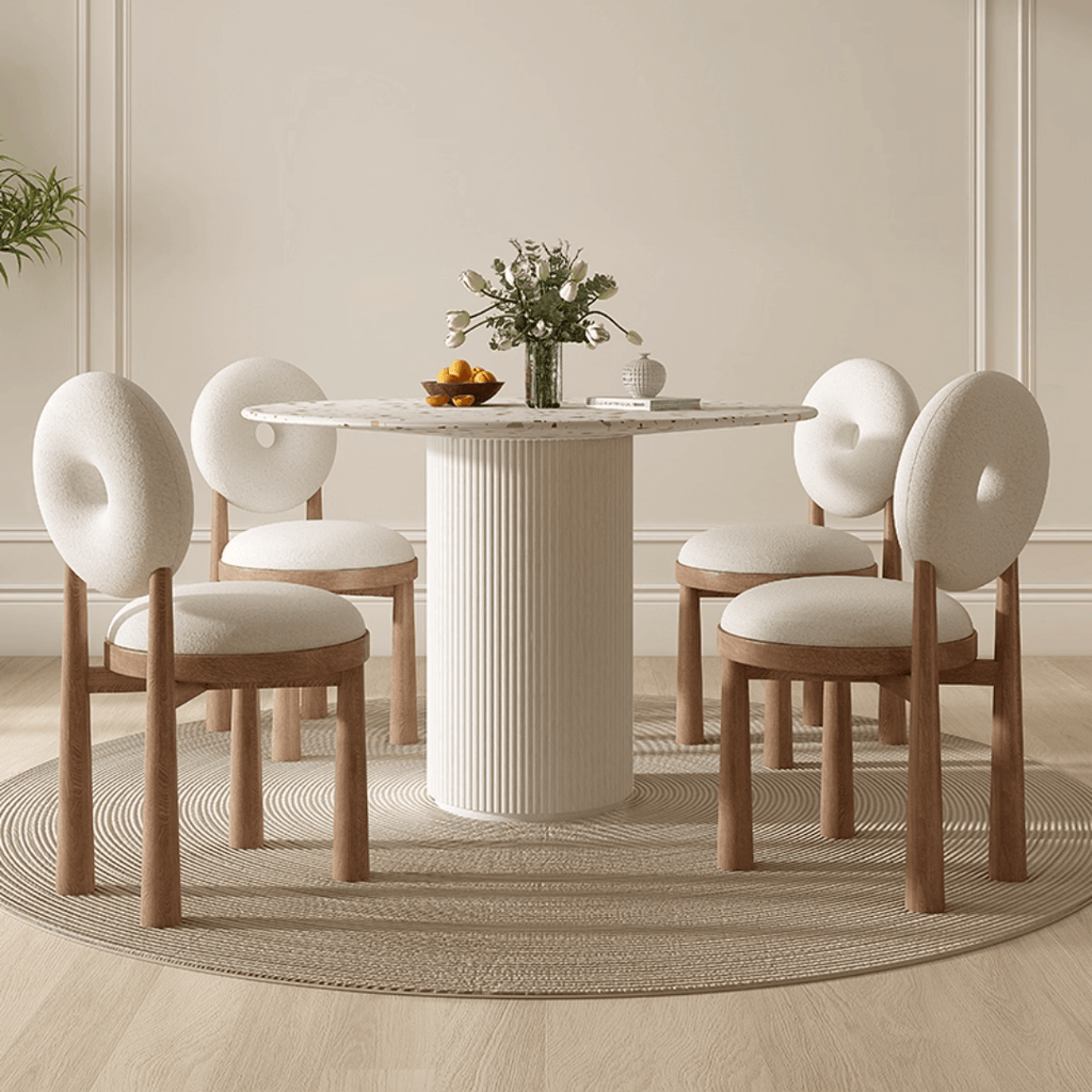 Round terrazzo dining table with soft wool upholstered chairs for a trendy home setup