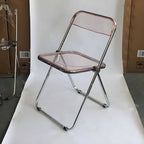 Contemporary acrylic folding armless chair with open back, ideal for dining rooms