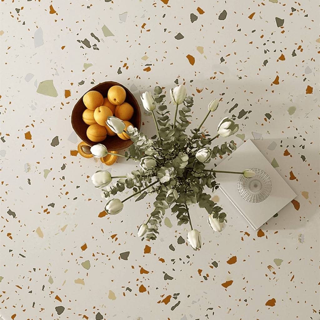 Round terrazzo dining table with soft wool upholstered chairs for a trendy home setup