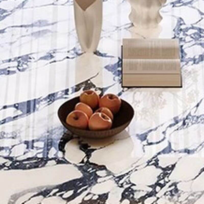 Oval marble dining table set with dual footing, solid back panel, and cushioned chairs