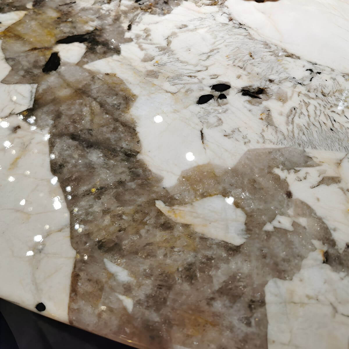 Oval marble dining table with white top and three gold steel legs