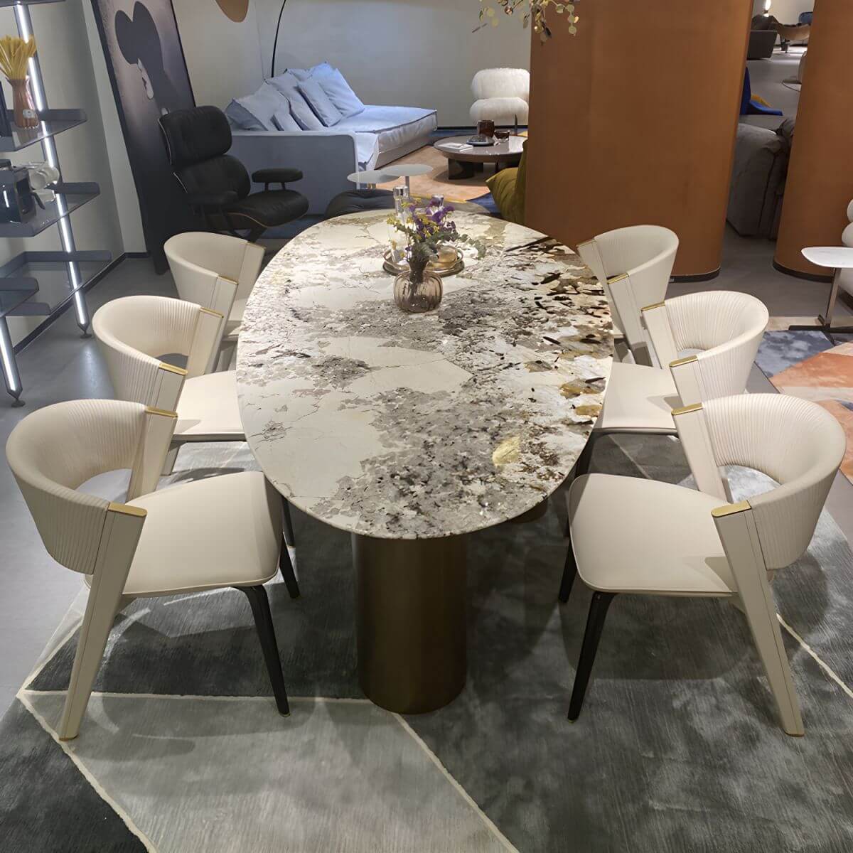 Oval marble dining table with white top and three gold steel legs