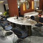 Oval marble dining table with white top and three gold steel legs