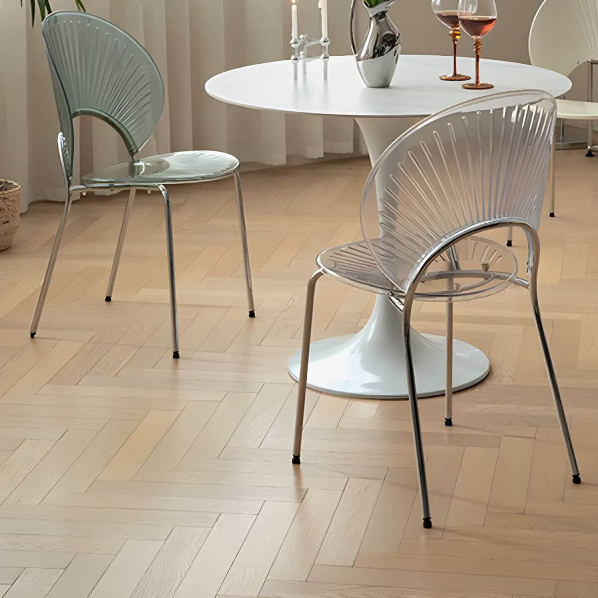 Stackable Scandinavian style dining chair with plastic seat, acrylic back, and silver legs