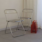 Contemporary acrylic folding armless chair with open back, ideal for dining rooms