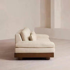 Cream Art Deco floor sofa with pillow back, pillow top arms, slipcover, and multiple pillows for seating 2 to 4 people