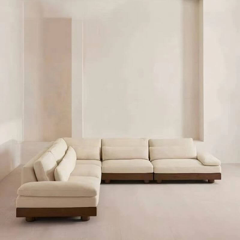 Cream Art Deco floor sofa with pillow back, pillow top arms, slipcover, and multiple pillows for seating 2 to 4 people