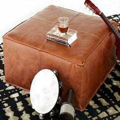 Brown upholstered accent stool from a modern collection