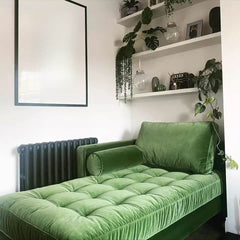 Layers of pillows on the green chaise