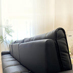 Sleek ink upholstered sofa against a light wall