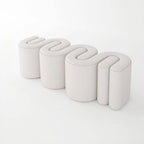 Blue upholstered stool against modern backdrop