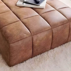 Contemporary upholstered stool placed beside couch