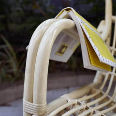 Rattan rocking chair beside a window