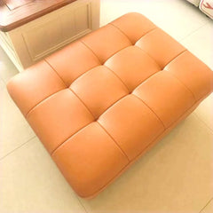 Orange upholstered footstool for vibrant spaces