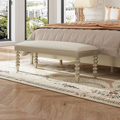 Side view of beige upholstered bedroom bench