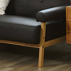 Black Scandinavian style small sofa with wood frame and faux leather upholstery
