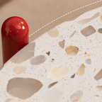 Round side table with vibrant red terrazzo top, featuring a modern minimalist design