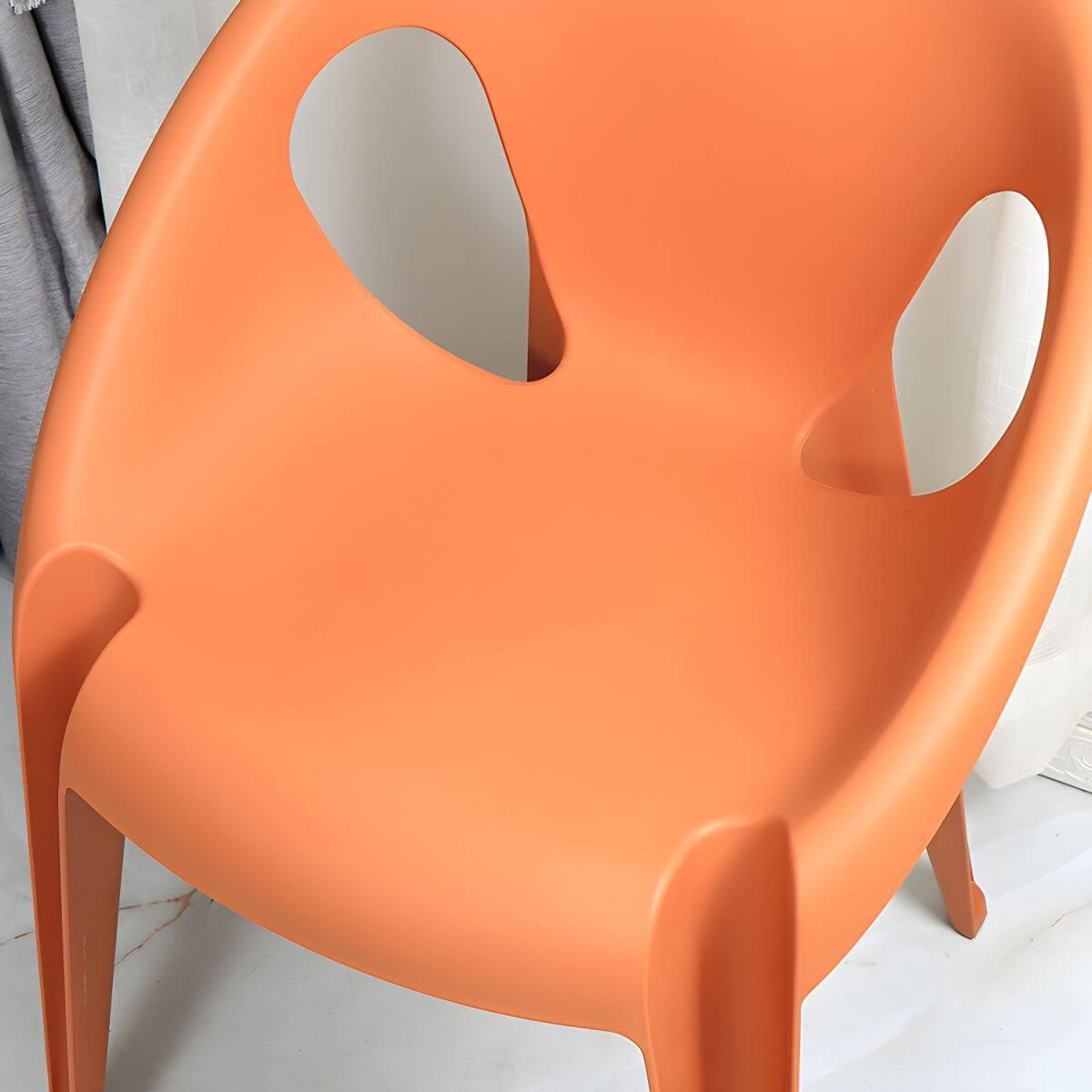 Stackable modern arm chair with open back made of plastic and acrylic for dining