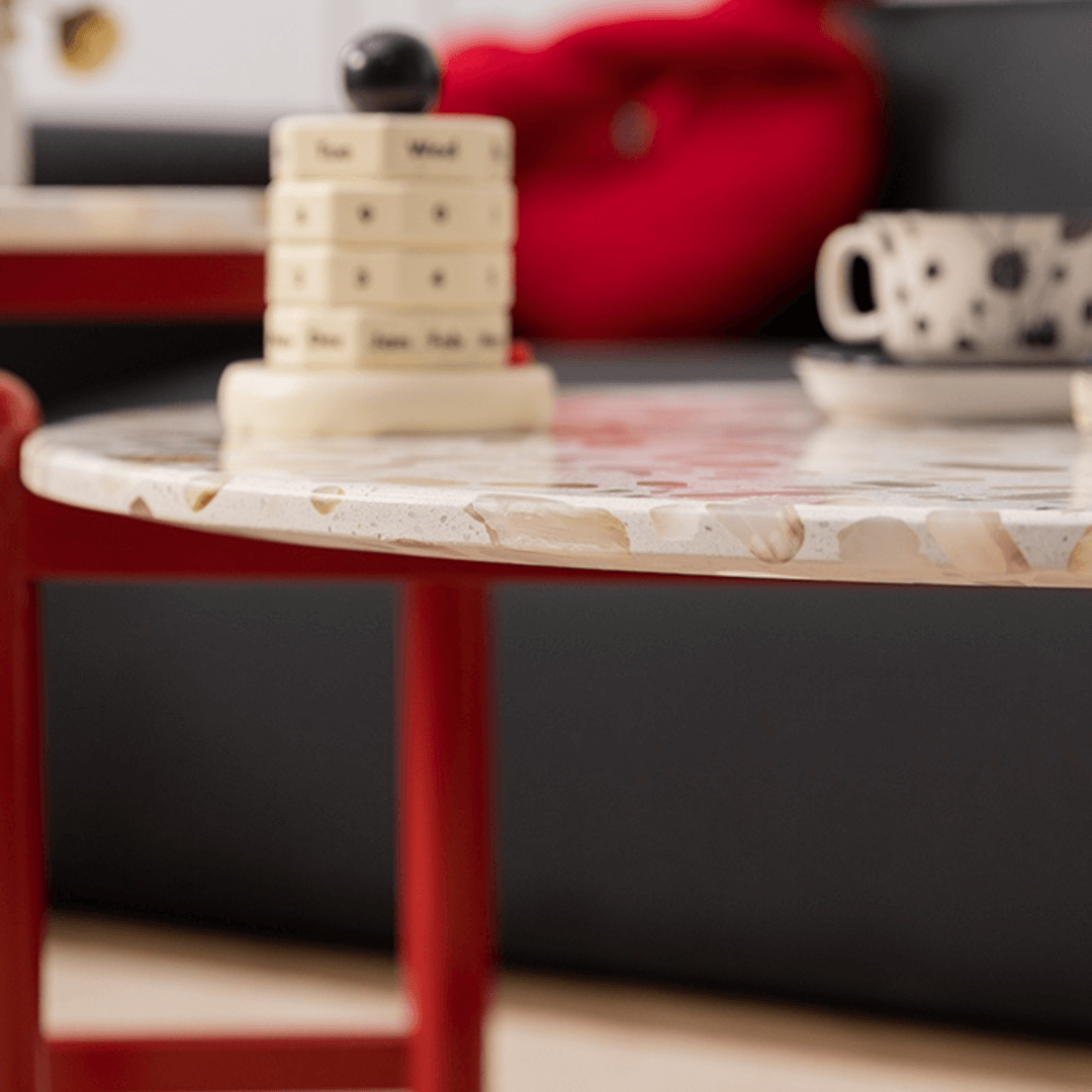 Round side table with vibrant red terrazzo top, featuring a modern minimalist design