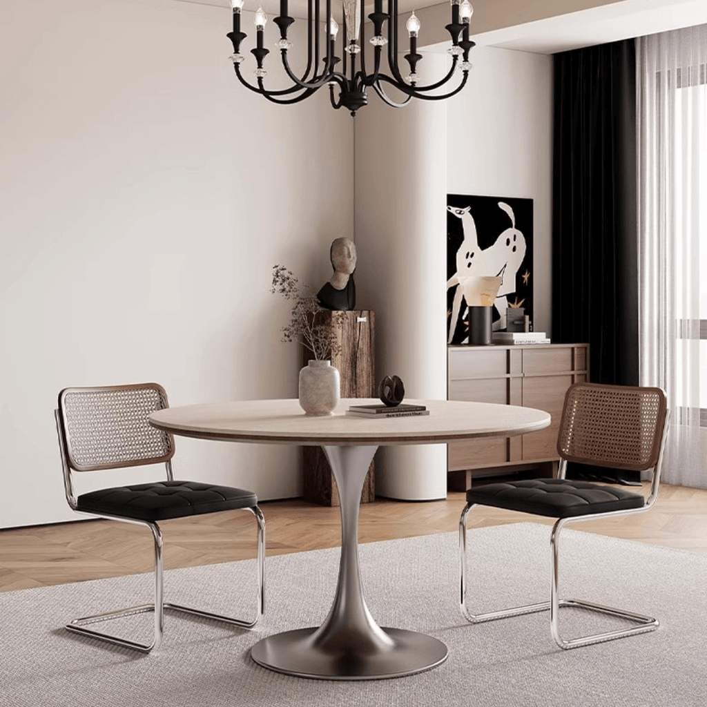 Round dining table with beige rock tabletop and stainless steel legs