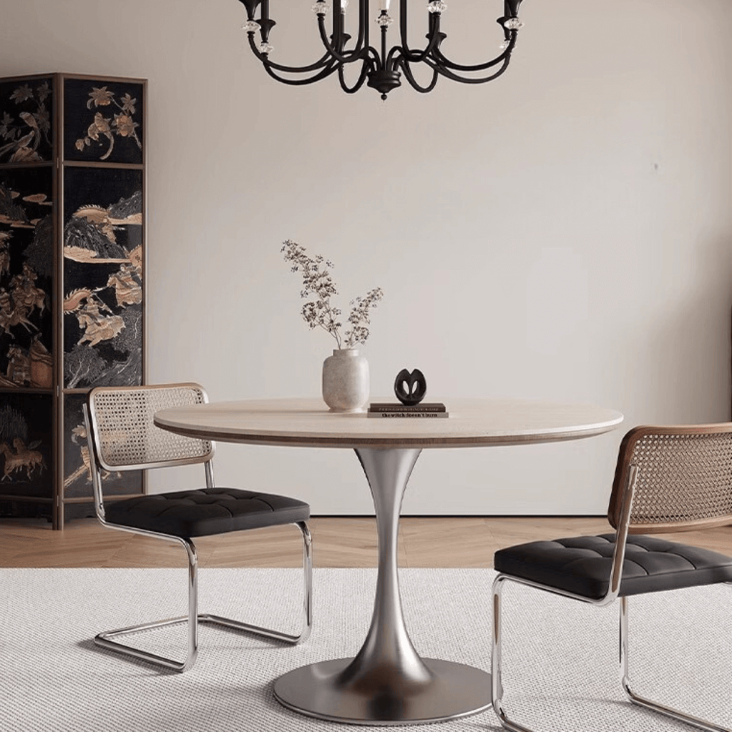 Round dining table with beige rock tabletop and stainless steel legs