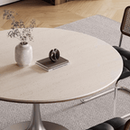 Round dining table with beige rock tabletop and stainless steel legs