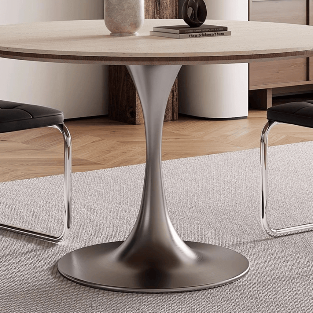 Round dining table with beige rock tabletop and stainless steel legs