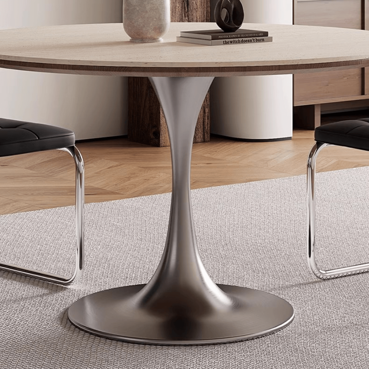 Round dining table with beige rock tabletop and stainless steel legs