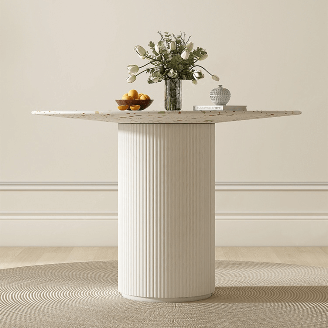 Round terrazzo dining table with soft wool upholstered chairs for a trendy home setup