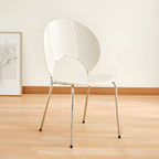 Stackable Scandinavian style dining chair with plastic seat, acrylic back, and silver legs