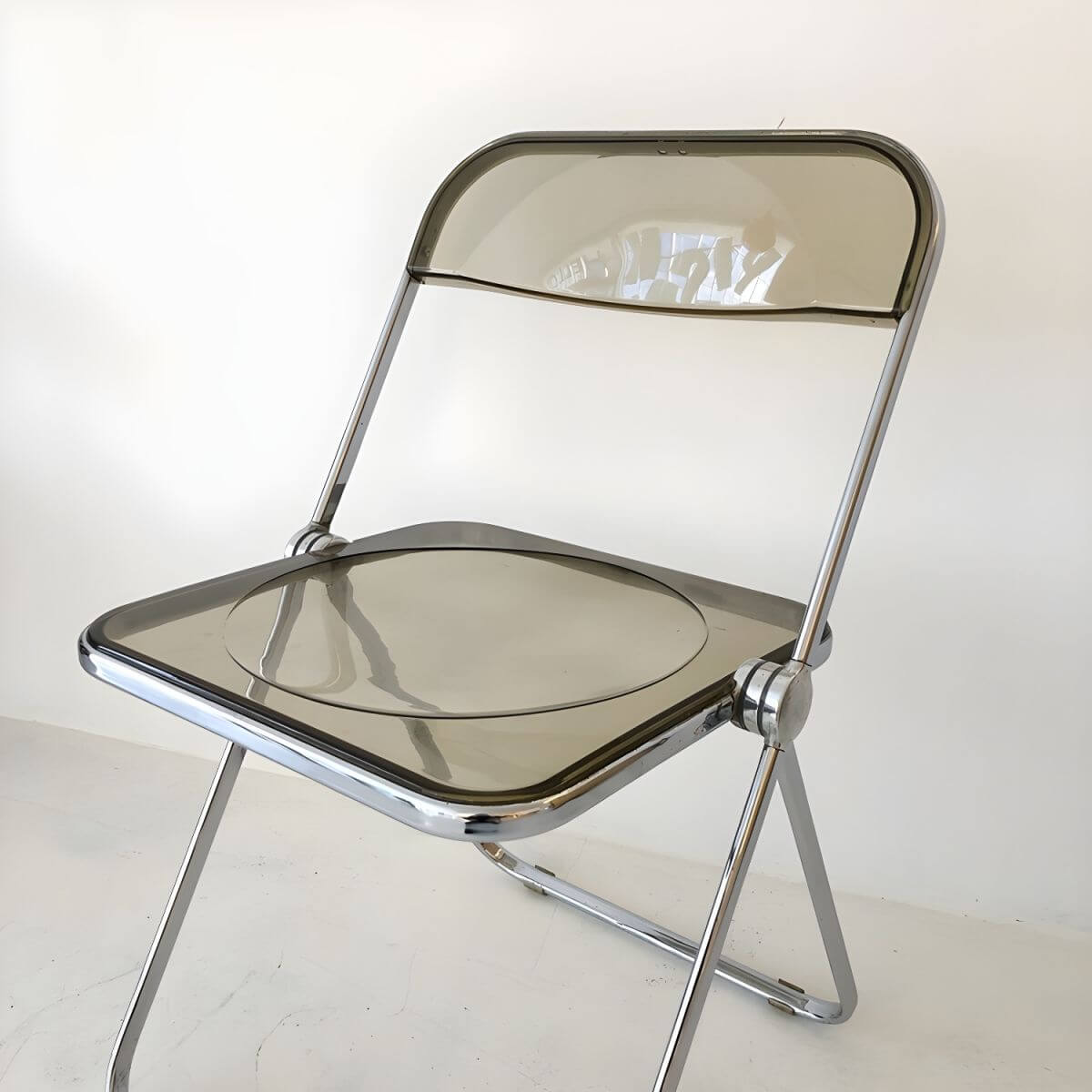 Contemporary acrylic folding armless chair with open back, ideal for dining rooms